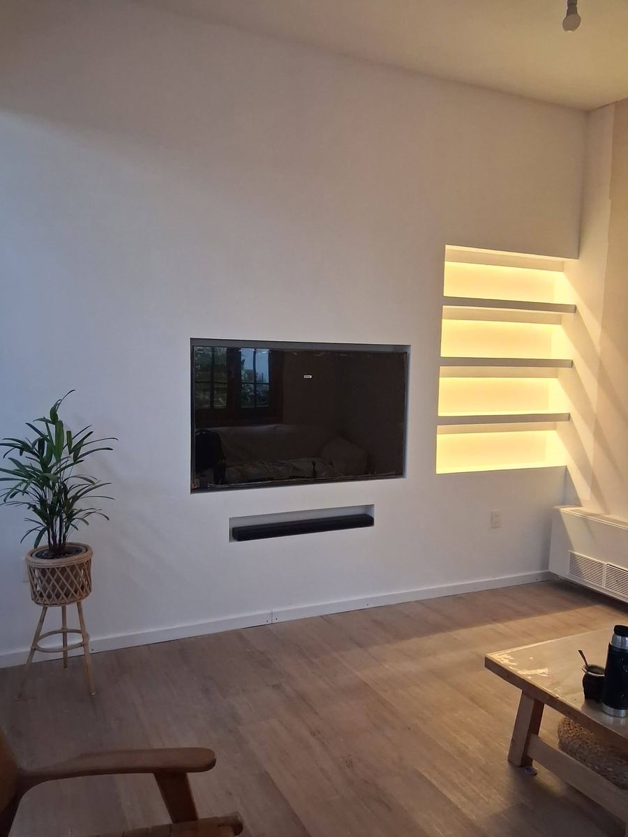 Pared de yeso terminada con televisor empotrado y nichos con luz